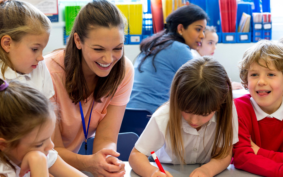 Female teaching assistant with primary school students