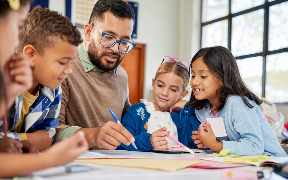 Male school worker with children in the classroom