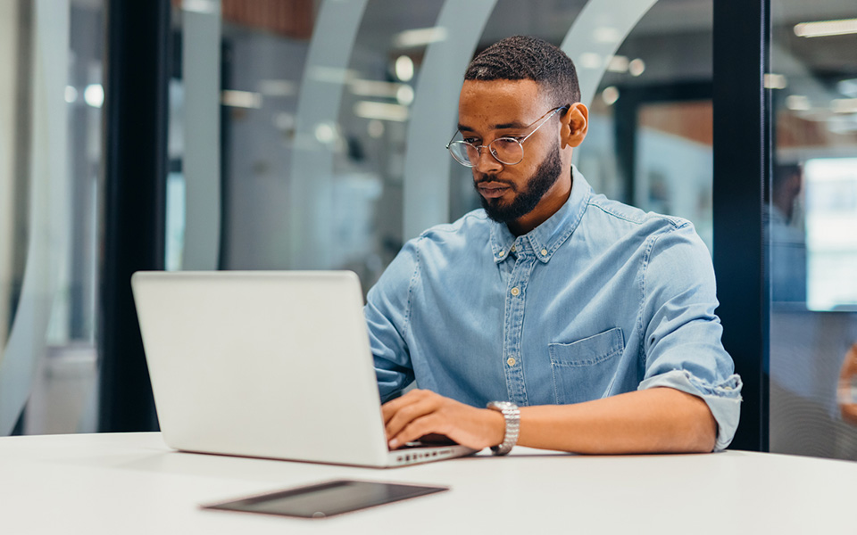 Young male working on laptop in an office environment