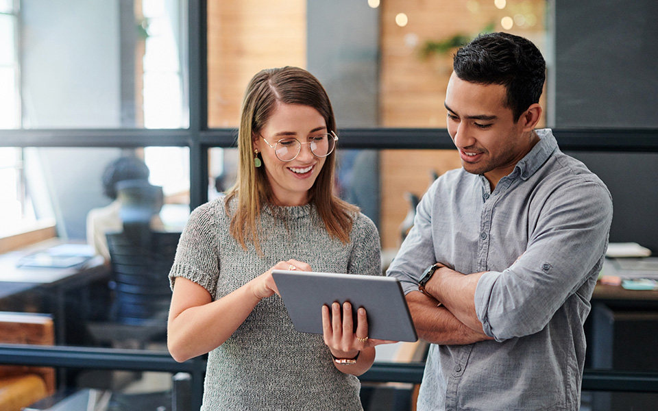 Two colleagues discussing work within an office setting