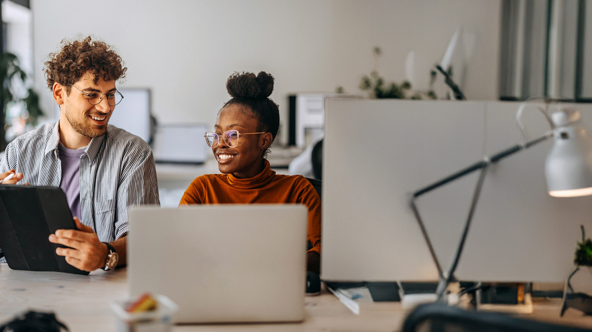 Male and female colleagues discussing work at a desk