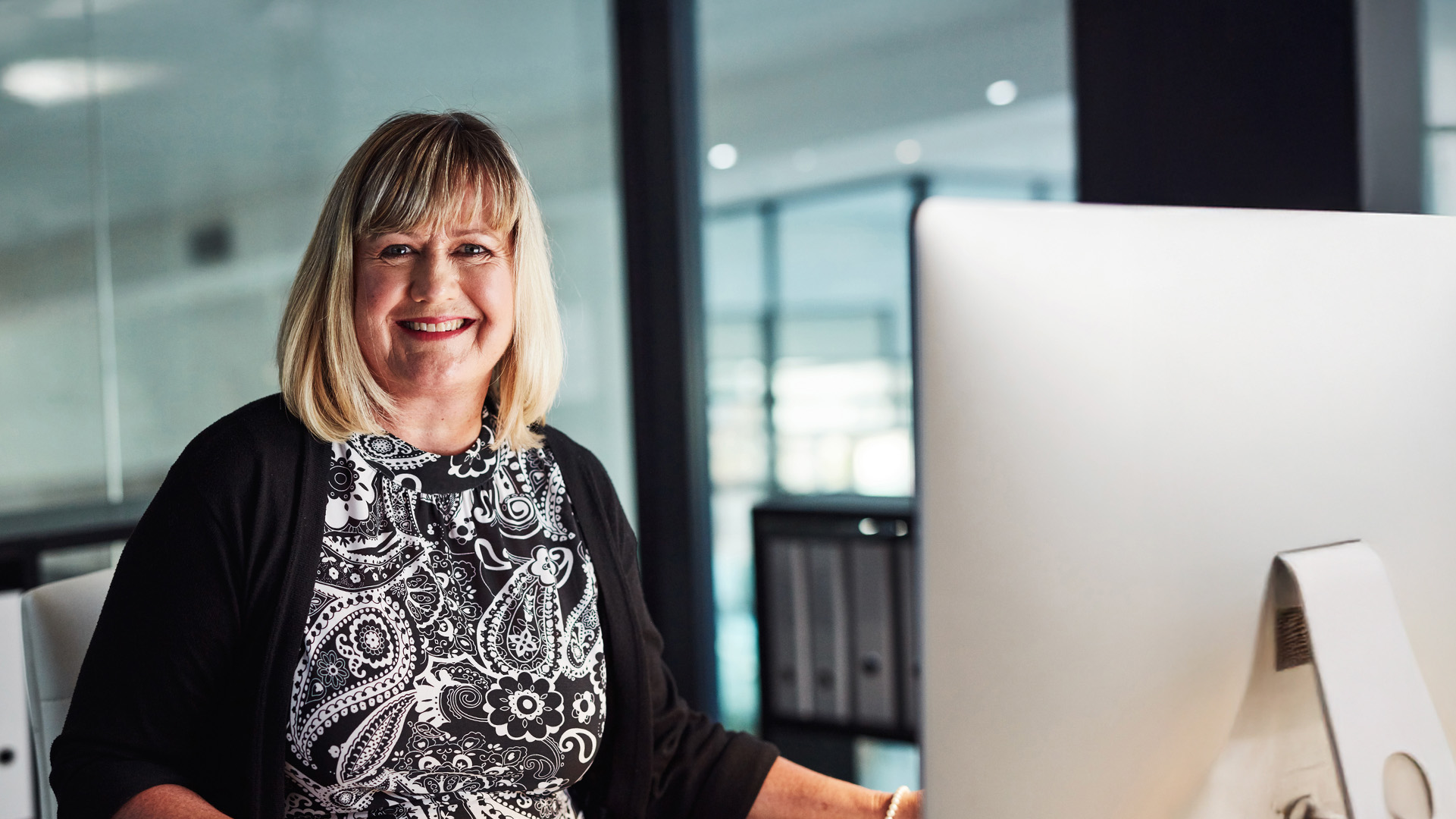 Female office manager working on the computer and smiling
