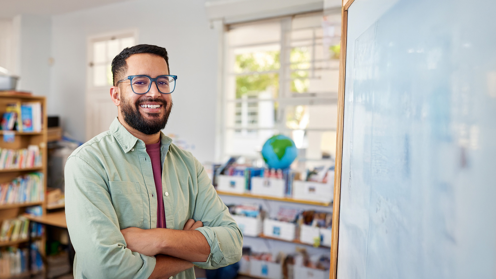 Male teacher looking at camera in a classroom setting