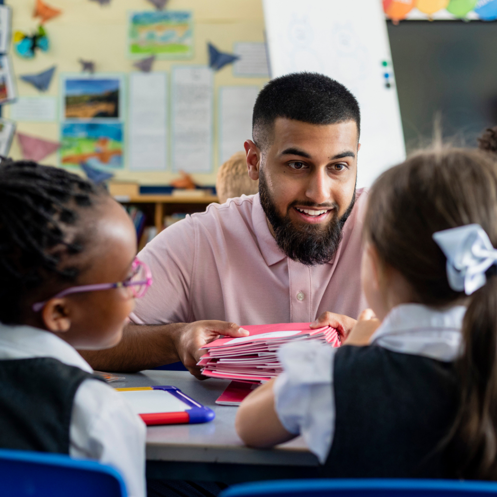 Male teaching assistant with 2 young children in classroom