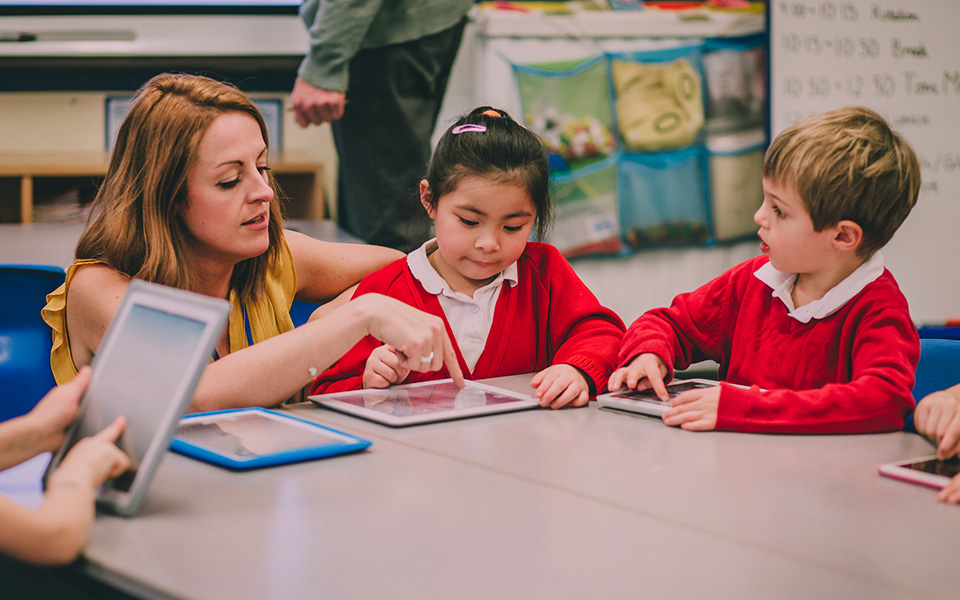 Teaching assistant working with primary school students