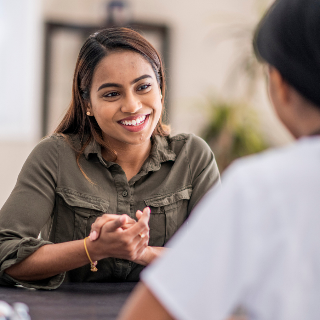 Female wellbeing champion in a school talking to another person