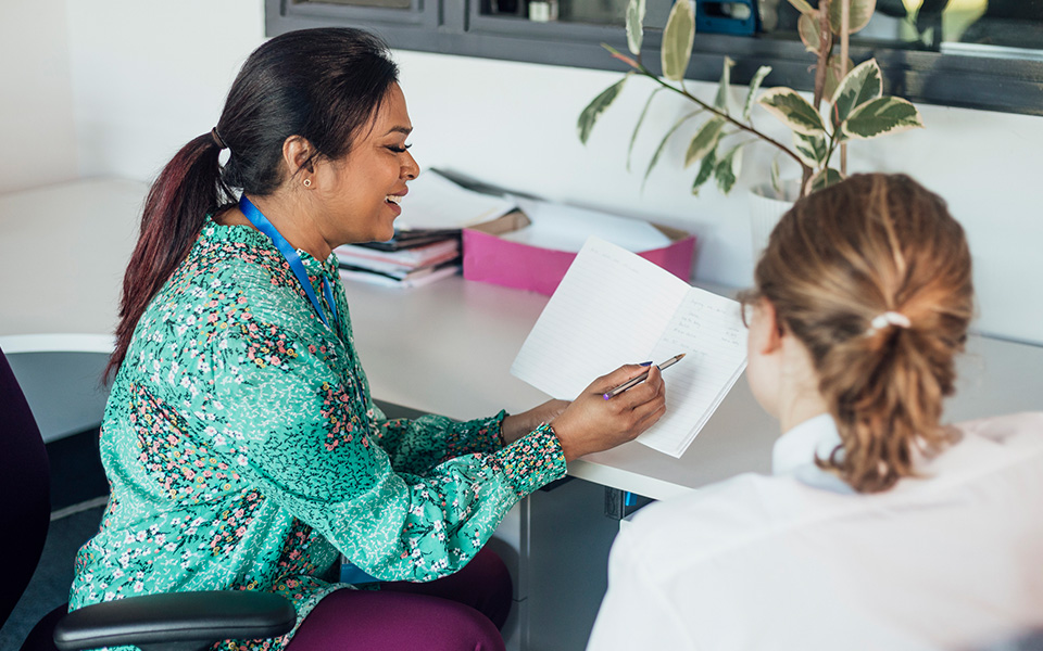 Female teacher helping a high school student with work