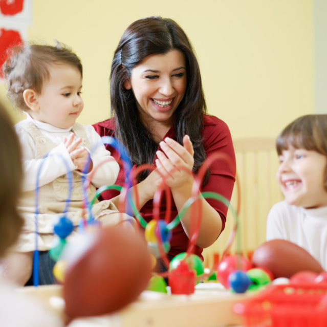 Female apprentice in nursery with young children