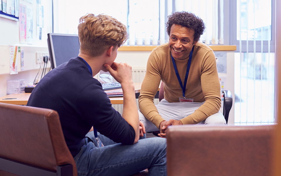 Male officer listening to student in an office