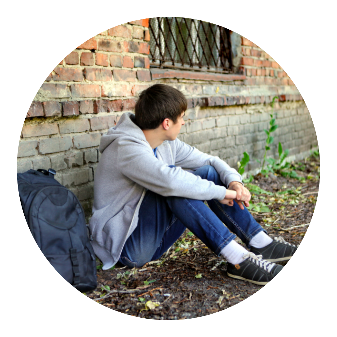 teenage boy sitting on the floor looking away from the camera