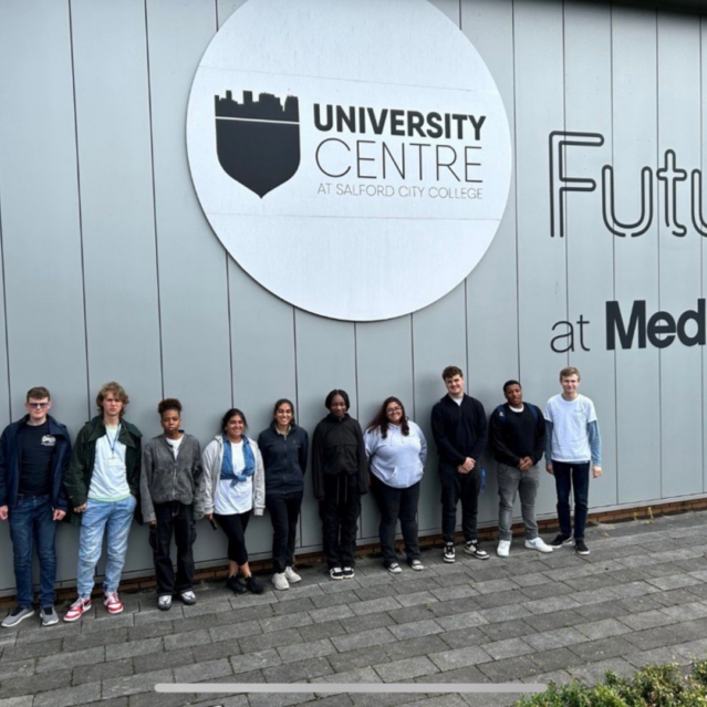 A group of young people standing under a sign reading "university centre".