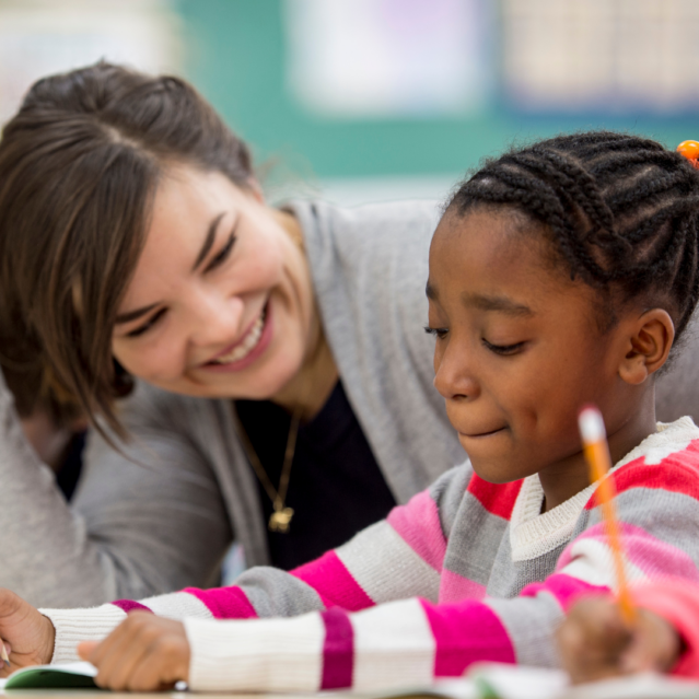 A teacher smiling at a young child